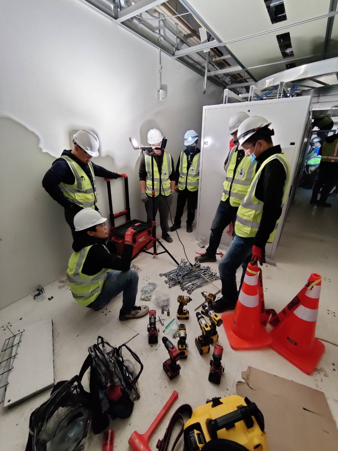 Integration crew staging tools and hardware beside a Claytek cabinet