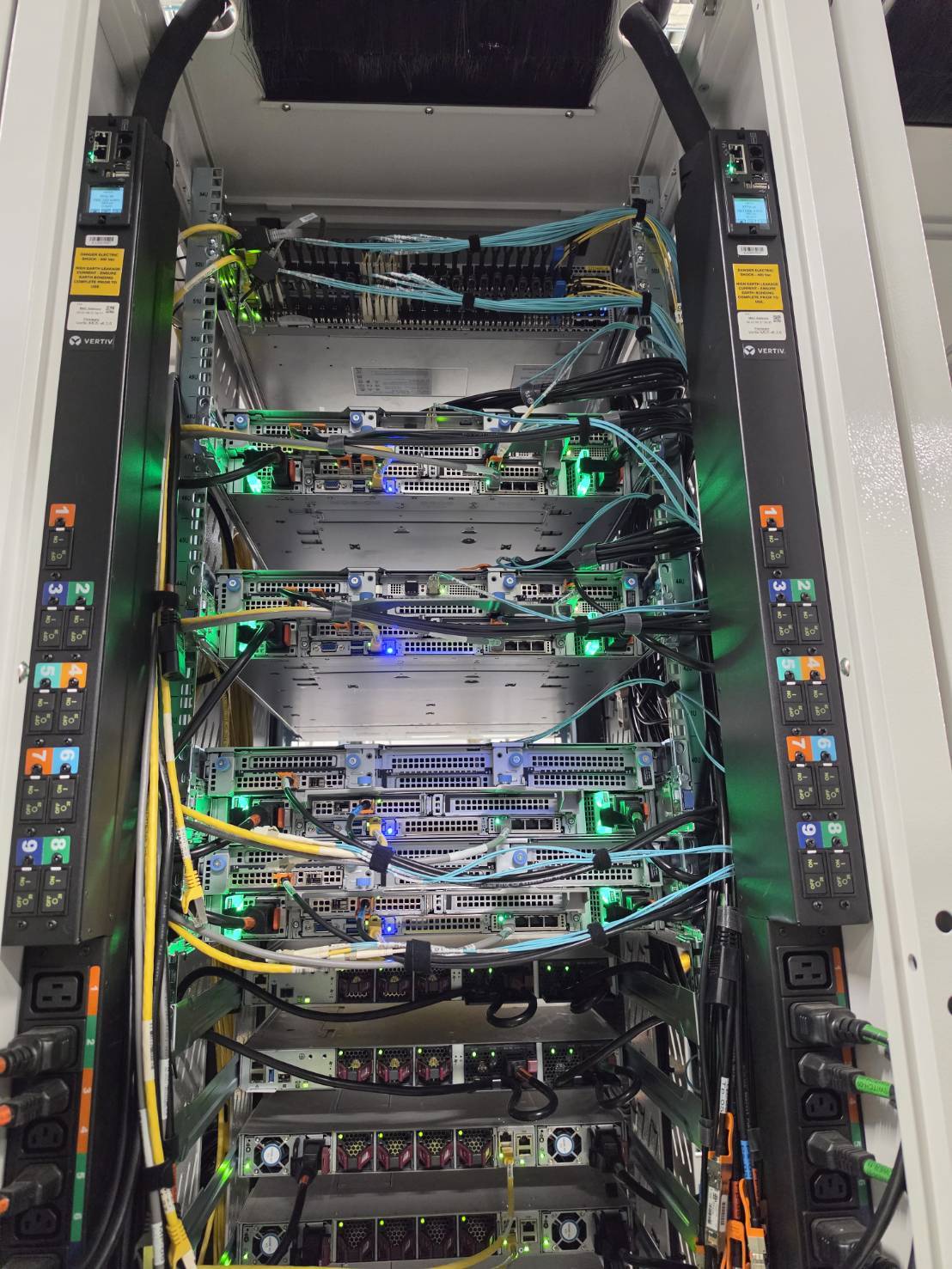 Populated server rack with dual PDUs, structured copper, and live storage