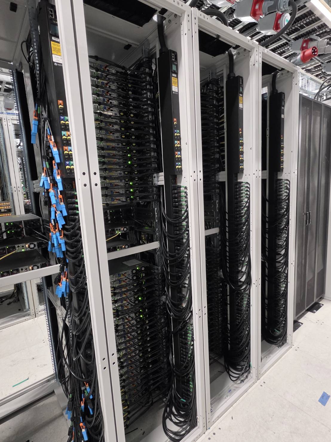 Rear of populated racks showing PDU whip, power connectors, and cable management