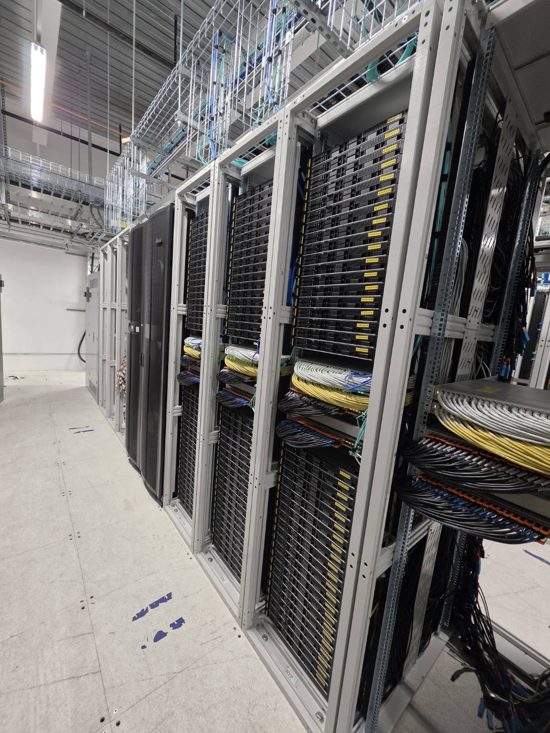 Row of integrated racks with overhead tray and dressed copper bundles