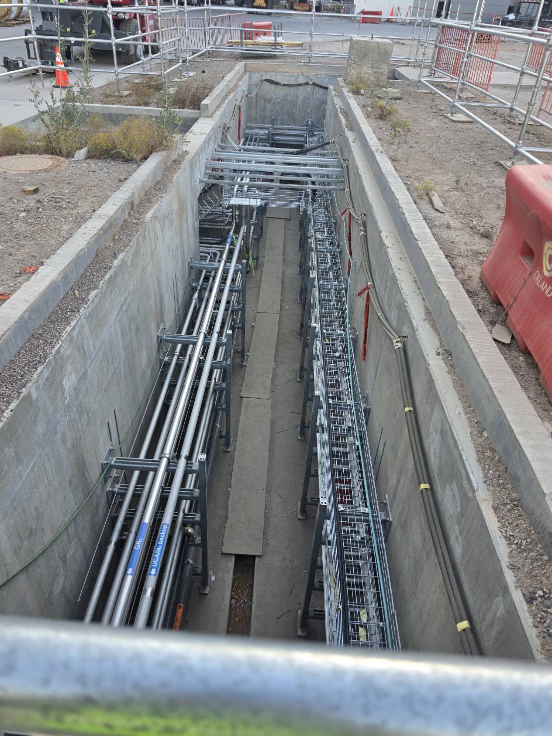 Long underground trench with tray on one side and conduit on the other
