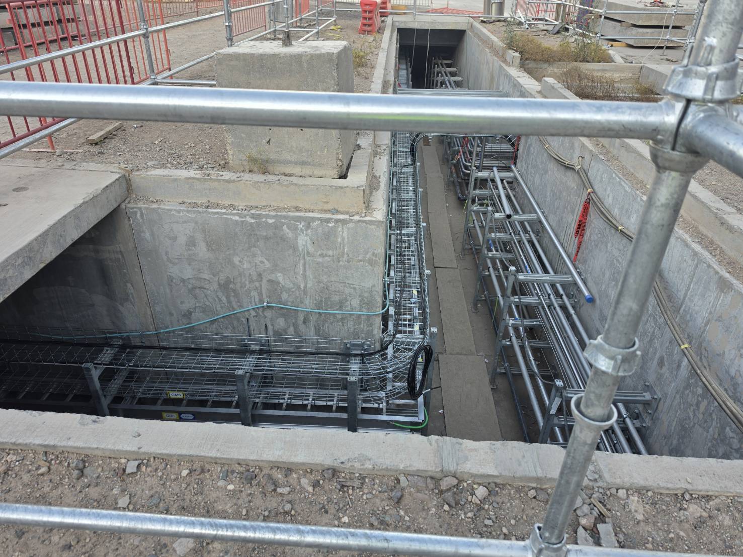 Underground cable tray turning through a concrete pathway vault