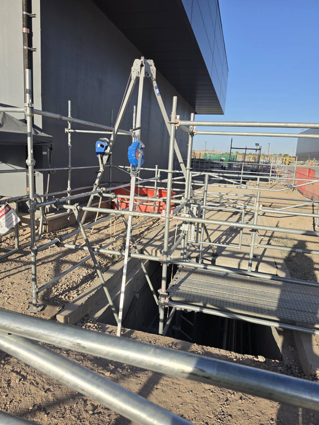 Scaffold and hoist over a building pathway vault at grade